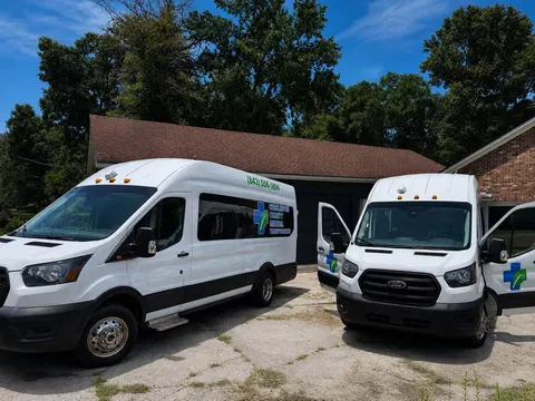 Two white Ford Transit vans, one viewed from the front with its cab doors open