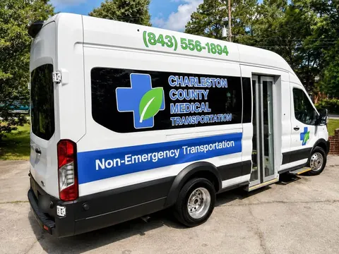 Passenger side and rear of a white Ford Transit high-roof van showing the curbside entry door